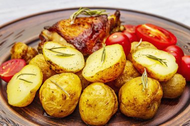 Kızarmış tavuk butları ve bebek patatesler.