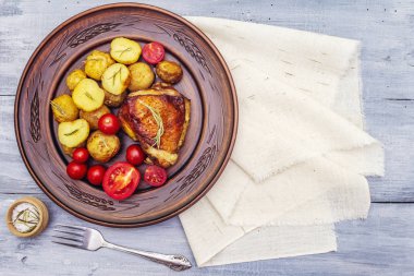Kızarmış tavuk butları ve bebek patatesler.