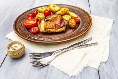 Kızarmış tavuk butları ve bebek patatesler.