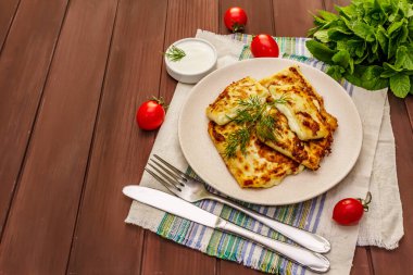 Sıcak aperatif, peynirli ve otlu pita ekmeği. Vejetaryen sağlıklı yiyecekler. Tahta tablo arkaplanı, kopyala