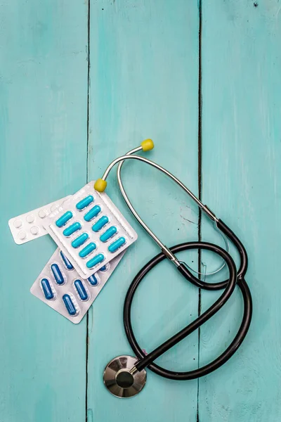 Clinical trial concept. Chalk board, stethoscope, pills. Wooden boards background