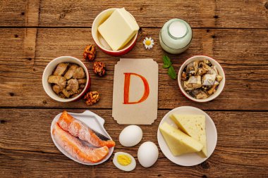 D vitamini, peynir, yumurta, tereyağı, fındık, süt, sardalya, somon, ciğer içeren yiyecekler. Eski tahta arka plan