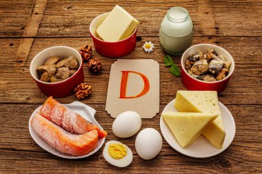 D vitamini, peynir, yumurta, tereyağı, fındık, süt, sardalya, somon, ciğer içeren yiyecekler. Eski tahta arka plan