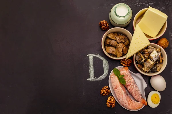 D vitamini içeren yiyecekler. Peynir, yumurta, tereyağı, fındık, süt, sardalya. Siyah tebeşir tahtası arkaplanı