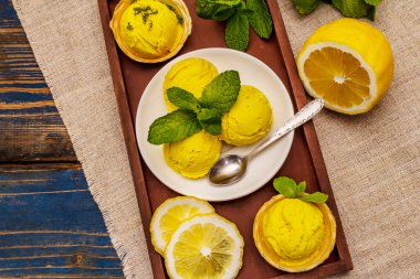 Naneli limonlu dondurma. Ferahlatıcı yaz tatlıları, olgun meyveler, mis kokulu yapraklar. Tahta kaplama arka plan, üst görünüm