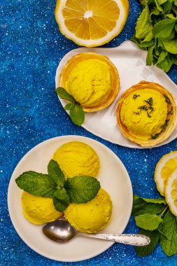 Naneli limonlu dondurma. Ferahlatıcı yaz tatlıları, olgun meyveler, mis kokulu yapraklar. Deniz mavisi arka plan, üst görünüm