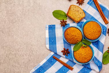 Tarçınlı ev yapımı kekler, yıldız anason ve taze nane. Fırın konsepti, yemek pişirmek için gerekli malzemeler. Taş beton zemin, üst görünüm