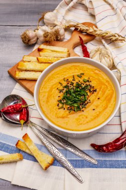 Sebze kremalı çorba. Sağlıklı vejetaryen beslenme konsepti. Sarımsak, kızarmış ekmek, baharat, aromatik baharatlar. Tahta kaplama arka plan, kapat