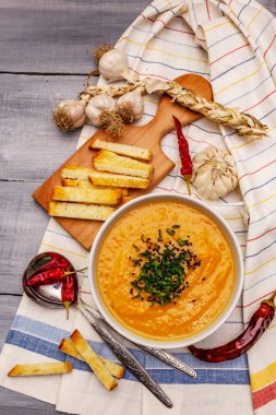 Sebze kremalı çorba. Sağlıklı vejetaryen beslenme konsepti. Sarımsak, kızarmış ekmek, baharat, aromatik baharatlar. Tahta kaplama arka plan, üst görünüm