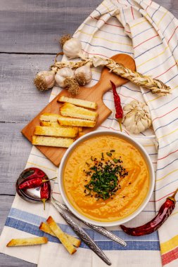 Sebze kremalı çorba. Sağlıklı vejetaryen beslenme konsepti. Sarımsak, kızarmış ekmek, baharat, aromatik baharatlar. Tahta kaplama arka plan, üst görünüm