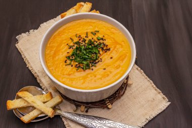 Sebze kremalı çorba. Sağlıklı vejetaryen beslenme konsepti. Sarımsak, kızarmış ekmek, baharat, aromatik baharatlar. Moda siyah tahta tahtalar arka plan, kopyalama alanı