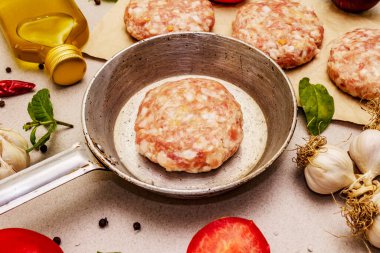 Çiğ pirzola, taze sebze, baharat, zeytinyağı. Klasik tava, piknik ya da barbekü pişirme konsepti. Taş beton arka plan, kapat