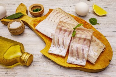 Çiğ hake fileto. Limon, tuz, baharat. Sağlıklı beslenme kavramı. Hafif tahta arka plan, kapat