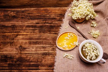 Taze yaşlı çiçeklerin çayı. Sıcak içecek, tatlım, alternatif tıp. Eski tahta arka plan, üst görünüm