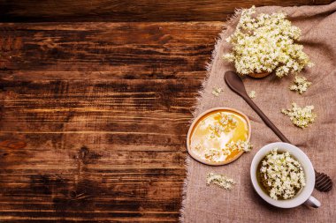 Taze yaşlı çiçeklerin çayı. Sıcak içecek, tatlım, alternatif tıp. Eski tahta arka plan, üst görünüm