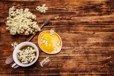 Taze yaşlı çiçeklerin çayı. Sıcak içecek, tatlım, alternatif tıp. Eski tahta arka plan, üst görünüm