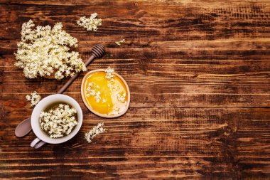 Taze yaşlı çiçeklerin çayı. Sıcak içecek, tatlım, alternatif tıp. Eski tahta arka plan, üst görünüm