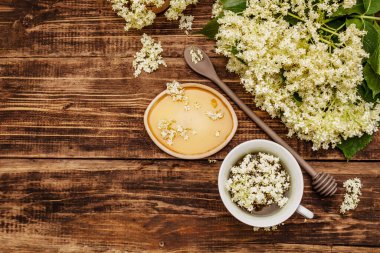 Taze yaşlı çiçeklerin çayı. Sıcak içecek, tatlım, alternatif tıp. Eski tahta arka plan, üst görünüm