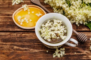 Taze yaşlı çiçeklerin çayı. Sıcak içecek, tatlım, alternatif tıp. Eski tahta arka plan, üst görünüm