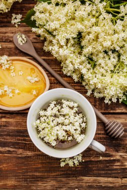 Taze yaşlı çiçeklerin çayı. Sıcak içecek, tatlım, alternatif tıp. Eski tahta arka plan, üst görünüm