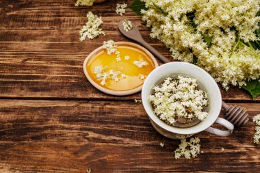 Taze yaşlı çiçeklerin çayı. Sıcak içecek, tatlım, alternatif tıp. Eski tahta arka plan, üst görünüm