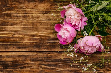 Güzel kokulu pembe şakayıklar. Eski ahşap arka planda güzel bir buket. Romantik ruh hali konsepti, üst görünüm