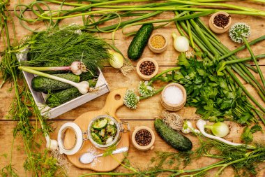 Sebze turşusu. Yemek pişirme süreci, baharatlar, taze kokulu bitkiler. Olgun salatalıklar, eski ahşap masa