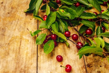 Dallarda olgun kiraz. Taze böğürtlen, sağlıklı tatlı. Eski tahta arka plan