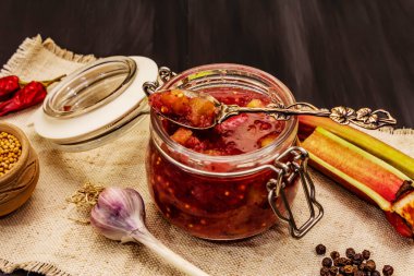 Chutney from rhubarb. Set of ingredients and spices for cooking. Black wooden background, close up clipart