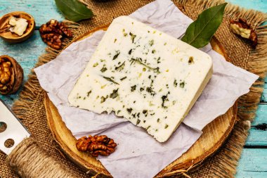 Küflü peynir. Peynir tabağı için. Fındık, kokulu defne yaprakları, bıçak. Moda turkuaz tahta tahta arka plan, kapat