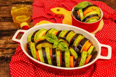 Pişirmek için taze sebzeler. Zeytinyağı, patlıcan, kabak, havuç, baharat ve fesleğen. Eski ahşap arka plan, kapat