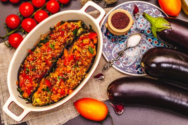 Karniyarik geleneksel Türk yemekleri. Kıyma, domates, yeşillik ve susamlı patlıcan dolması. Siyah taş arkaplan, üst görünüm