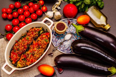 Karniyarik geleneksel Türk yemekleri. Kıyma, domates, yeşillik ve susamlı patlıcan dolması. Siyah taş arkaplan, üst görünüm