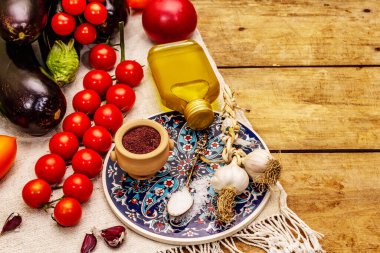 Geleneksel Türk yemeği İmam Bayildi 'nin hazırlanması için bir dizi ürün. Taze sebzeler, zeytinyağı ve sumak. Eski tahta arkaplan, kopyalama alanı