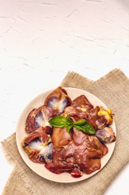 Taze çiğ tavuk sakatatı: kalp, karaciğer, mide. Kuru baharatlar, deniz tuzu, acı biber. Beyaz macun arkaplan, üst görünüm