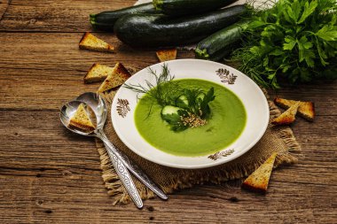 Yeşil kabak kremalı çorba. Sağlıklı vejetaryen yemeği, çıtır tost, susam tohumu, olgun meyveler, taze sebzeler. Eski tahta tahta arka plan, kopyalama alanı