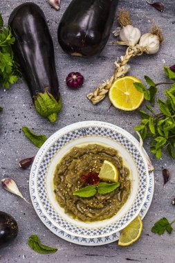 Patlıcan dalışı baba ganoush (mutabbal) veya olgun sebzeler ve taze otlarla mezze. Geleneksel Orta Doğu mutfağı, sağlıklı aperatif, vegan humus. Taş beton zemin, üst görünüm
