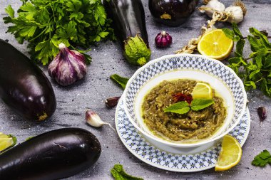 Patlıcan dalışı baba ganoush (mutabbal) veya olgun sebzeler ve taze otlarla mezze. Geleneksel Orta Doğu mutfağı, sağlıklı aperatif, vegan humus. Taş beton arka plan, kapat