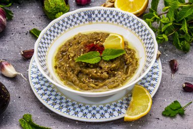 Patlıcan dalışı baba ganoush (mutabbal) veya olgun sebzeler ve taze otlarla mezze. Geleneksel Orta Doğu mutfağı, sağlıklı aperatif, vegan humus. Taş beton arka plan, kapat