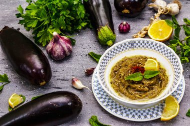 Patlıcan dalışı baba ganoush (mutabbal) veya olgun sebzeler ve taze otlarla mezze. Geleneksel Orta Doğu mutfağı, sağlıklı aperatif, vegan humus. Taş beton arka plan, kapat
