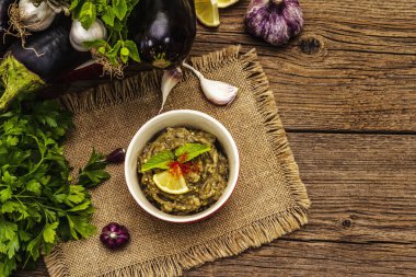 Patlıcan dalışı baba ganoush (mutabbal) veya olgun sebzeler ve taze otlarla mezze. Geleneksel Orta Doğu mutfağı, sağlıklı aperatif, vegan humus. Eski tahta arka plan, üst görünüm