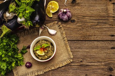 Patlıcan dalışı baba ganoush (mutabbal) veya olgun sebzeler ve taze otlarla mezze. Geleneksel Orta Doğu mutfağı, sağlıklı aperatif, vegan humus. Eski tahta arka plan, üst görünüm