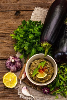 Patlıcan dalışı baba ganoush (mutabbal) veya olgun sebzeler ve taze otlarla mezze. Geleneksel Orta Doğu mutfağı, sağlıklı aperatif, vegan humus. Eski tahta arka plan, üst görünüm