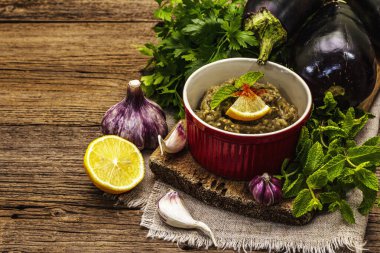 Patlıcan dalışı baba ganoush (mutabbal) veya olgun sebzeler ve taze otlarla mezze. Geleneksel Orta Doğu mutfağı, sağlıklı aperatif, vegan humus. Eski tahta tahta arka plan, kopyalama alanı