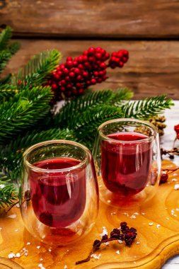 Bayram meyvesi likörü ya da çift duvarlı bardakta tentür. Alkol kokteyli hazırlamak için. Yeni yıl ya da Noel tasarımı, beyaz tahta arka plan, kapat