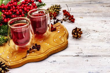 Bayram meyvesi likörü ya da çift duvarlı bardakta tentür. Alkol kokteyli hazırlamak için. Yeni yıl ya da Noel tasarımı, beyaz tahta kaplama arka plan, kopyalama alanı
