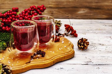 Bayram meyvesi likörü ya da çift duvarlı bardakta tentür. Alkol kokteyli hazırlamak için. Yeni yıl ya da Noel tasarımı, beyaz tahta kaplama arka plan, kopyalama alanı