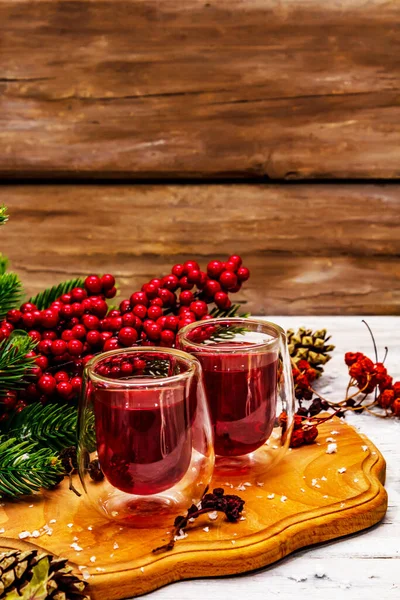 Bayram meyvesi likörü ya da çift duvarlı bardakta tentür. Alkol kokteyli hazırlamak için. Yeni yıl ya da Noel tasarımı, beyaz tahta kaplama arka plan, kopyalama alanı