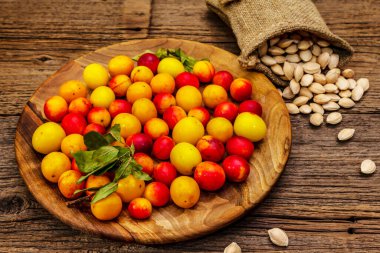 Olgun vişneli erik hasadı. Çuvalda meyve ve tohum çeşitleri var. Eski tahta tahta arka plan, kopyalama alanı