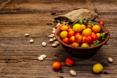 Olgun vişneli erik hasadı. Çuvalda meyve ve tohum çeşitleri var. Eski tahta tahta arka plan, kopyalama alanı